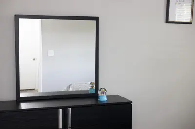a black dresser with a mirror on top of it at Cozy and Modern Vacation Home in Hallandale Beach