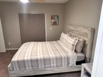 a bedroom with a large bed with a striped comforter at Cozy and Modern Vacation Home in Hallandale Beach