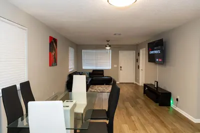 a dining room and living room with a glass table and chairs at Cozy and Modern Vacation Home in Hallandale Beach