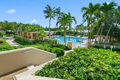a resort pool with palm trees and bushes at Leave the Worries Behind & Relax in Our Suite! in Miami