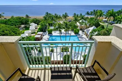 a balcony with chairs and a pool and the ocean at Leave the Worries Behind & Relax in Our Suite! in Miami