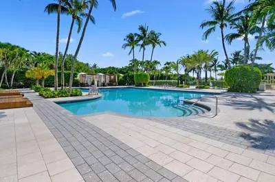 a swimming pool with palm trees in a resort at Leave the Worries Behind & Relax in Our Suite! in Miami