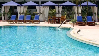 a swimming pool with chairs and tables and umbrellas at Condominium Sunny Isles Ocean Reserve in Sunny Isles Beach