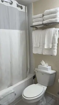 a bathroom with a toilet and a shower and towels at Departamento con salida al mar Miami in Sunny Isles Beach