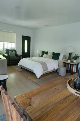 a bedroom with a large bed and a living room at Spacious Family 3BR Near Wynwood and Beach in Miami