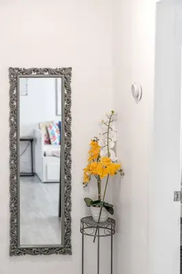 a mirror and a vase with flowers in a room at Biscayne Shore #2 - 3 2 - Charming and Tropical in Miami