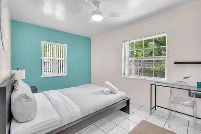 a bedroom with a bed and a blue wall at Bluewave Bungalow - #1 Charming & Comfortable 2 1 in Dania Beach