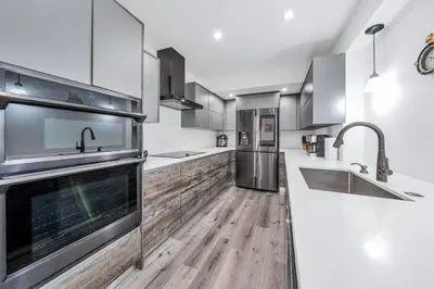 a kitchen with wooden floors and stainless steel appliances at 3 2 Family friendly Brand New Home w Pool in Miami