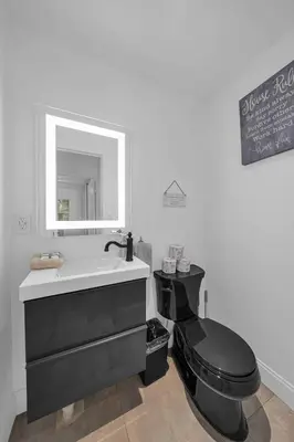 a bathroom with a black toilet and a sink at Renovated Gem: Prime Spotless Ideal in Miami