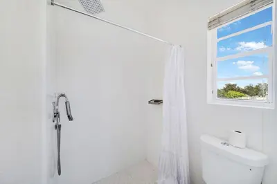 a white bathroom with a shower and a window at Treehouse Hotel in Miami