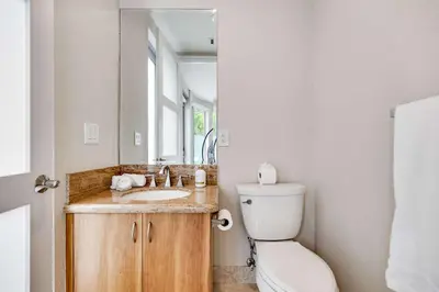 a bathroom with a sink and a toilet and a mirror at 4-Bed + Den with pool in Las Olas Ft Lauderdale in Fort Lauderdale