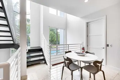 a white dining room with a table and chairs at 4-Bed + Den with pool in Las Olas Ft Lauderdale in Fort Lauderdale