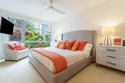 a bedroom with a bed and a chair and a window at 4-Bed + Den with pool in Las Olas Ft Lauderdale in Fort Lauderdale