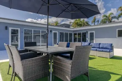 a table with chairs and an umbrella on a patio at Sunshine Manor 2009 in Fort Lauderdale