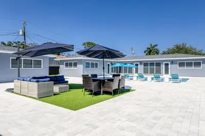 a patio with a table and chairs and umbrellas at Sunshine Manor 2009 in Fort Lauderdale