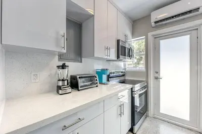 a kitchen with white cabinets and a counter top at Sunshine Manor 2013 in Fort Lauderdale