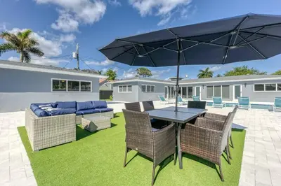 a patio with a table and chairs and an umbrella at Sunshine Manor 2013 in Fort Lauderdale