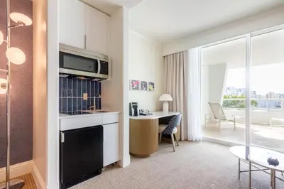 a living room with a kitchen and a room with a table at Fontainebleau in Miami Beach
