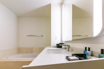 a bathroom with a sink and a bath tub at Fontainebleau in Miami Beach
