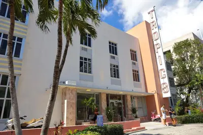 a building with palm trees in front of it at Tropics Hotel Miami Beach in Miami Beach