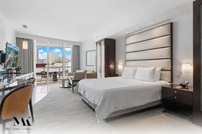 a hotel room with a large bed and a balcony at FontaineBleau Resort Balcony w Ocean and City View in Miami Beach