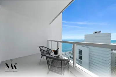 a balcony with a table and chairs and the ocean at FontaineBleau Resort Ocean plus Bay View w Balcony in Miami Beach