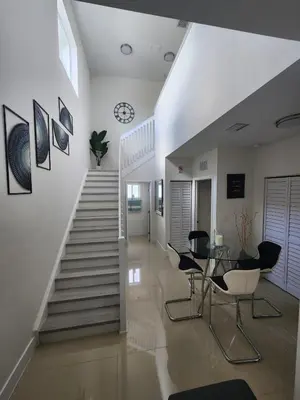 a hallway with a staircase and a table and chairs at The 305 in Miami