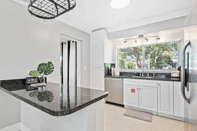 a kitchen with white cabinets and a black counter top at Copacabana in Fort Lauderdale
