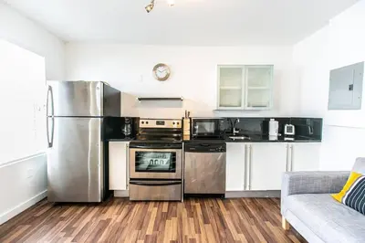 a kitchen with stainless steel appliances and a couch at 1 Bedroom 5 minutes walk to Beach on Washington Ave in Miami Beach