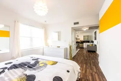 a white bedroom with a bed and a kitchen at 1 Bedroom 5 minutes walk to Beach on Washington Ave in Miami Beach
