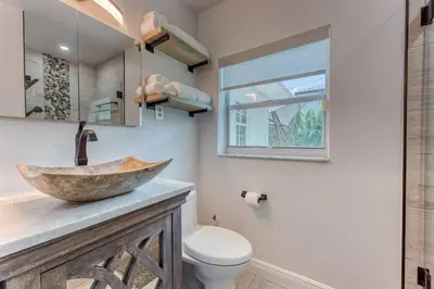 a bathroom with a stone sink and a toilet at Mango Manor - Walk to Las Olas! in Fort Lauderdale
