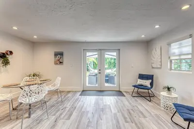 a living room with a table and chairs at Mango Manor - Walk to Las Olas! in Fort Lauderdale