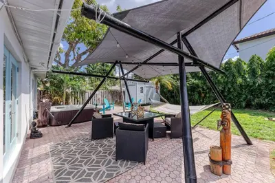 an umbrella on a patio with a table and chairs at Mango Manor - Walk to Las Olas! in Fort Lauderdale
