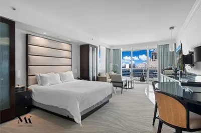 a hotel room with a large bed and a balcony at FontaineBleau Resort Balcony w Pool & Ocean View in Miami Beach