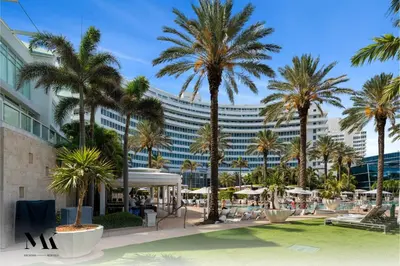 a resort with palm trees and a large building at FontaineBleau Resort Balcony w Pool & Ocean View in Miami Beach