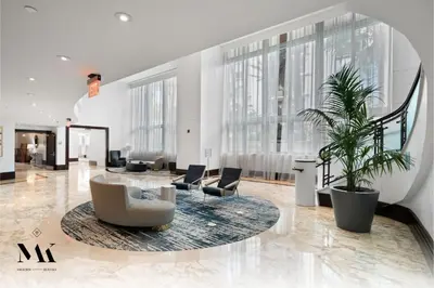 a large lobby with chairs and a table and plants at FontaineBleau Resort High Floor w Ocean Views in Miami Beach