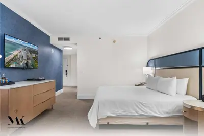 a bedroom with a large bed and a blue wall at FontaineBleau Resort High Floor w Ocean Views in Miami Beach