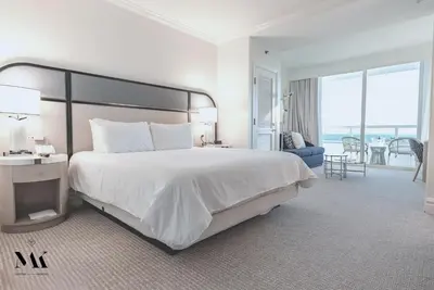 a large white bedroom with a large bed and a living room at FontaineBleau Resort High Floor w Ocean Views in Miami Beach
