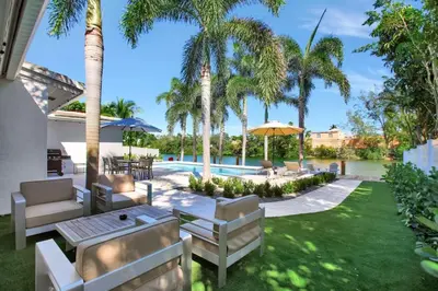 a backyard with palm trees and a swimming pool at Lakefront Family Fun Home with Private Dock 3BR 2B in Fort Lauderdale