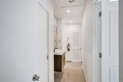 a white bathroom with a sink and a white door at Wilton on the water courtyard and Heated Pool in Fort Lauderdale
