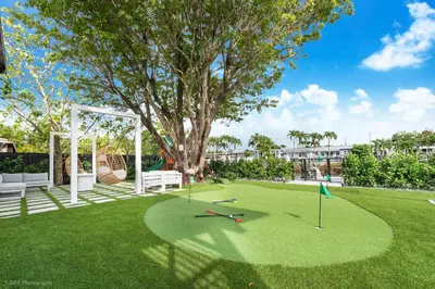 a golf course with a tree and a swing at The World's Mansion - Game Room, 9 Bedrooms, Htd Pool, Mini Golf, BBQ in Tamiami