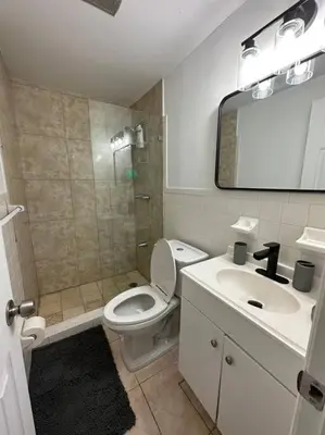 a bathroom with a toilet and a sink and a mirror at Stylish Studio Brickell/Little Havana@ItalianPlaza in Miami