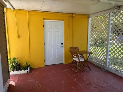 a porch with a chair and a white door at Stylish Studio Brickell/Little Havana@ItalianPlaza in Miami