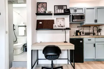 a kitchen with white cabinets and a black chair at Coral Way Studio in quiet area Fast Internet Shen 1 in Miami