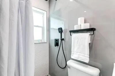 a white bathroom with a shower and a toilet at Coral Way Studio in quiet area Fast Internet Shen 1 in Miami