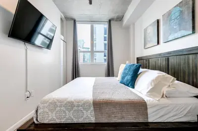 a bedroom with a bed with a television on the wall at Super convenient 1br apartment in Downtown 4 p 1708 in Miami