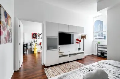 a white room with a tv and a bed at Stylish 2br Apt in Downtown City View 3208 in Miami