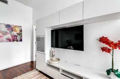 a living room with a tv on a white wall at Stylish 2br Apt in Downtown City View 3208 in Miami
