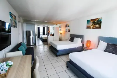 a hotel room with two beds and a living room at Castle 1205 Beachfront Studio with Free Parking, Beach Access, Pool, Tennis in Miami Beach