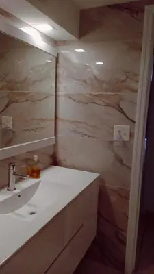 a bathroom with a sink and a marble wall at Ocean Reserve in Sunny Isles Beach